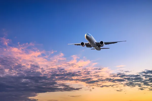 An airplane flying at sunset