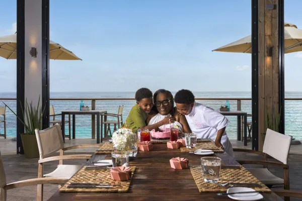 A family hugging around a dining table celebrating with cake