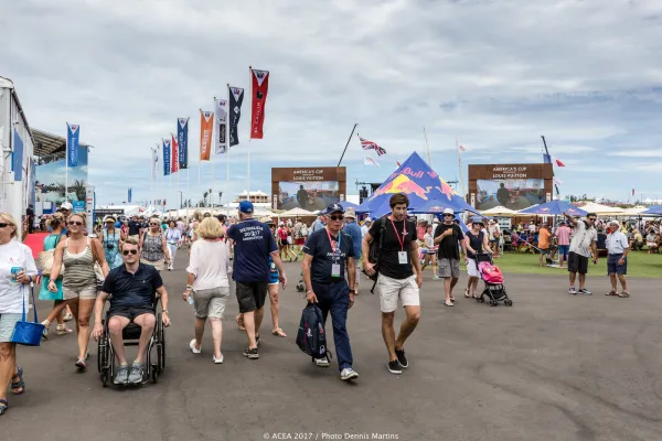 A man wheels his wheelchair in a crowded pavilion for the America's Cup in Bermuda