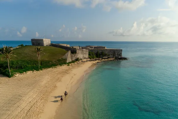 The fort at Tobacco Bay, overlooking two people riding horses on the beach