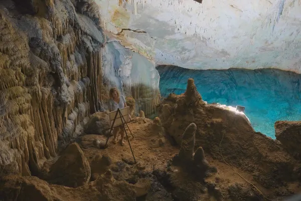 A woman painting on a canvas in a cave in Bermuda