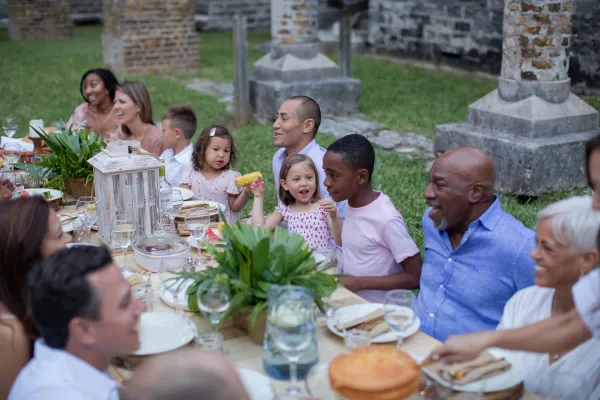 A large family having an outdoor dinner at the Unfinished Church in Bermuda