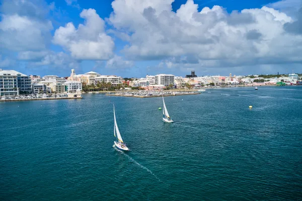 Two sailboats traversing the Hamilton, Bermuda's harbour on a sunny day