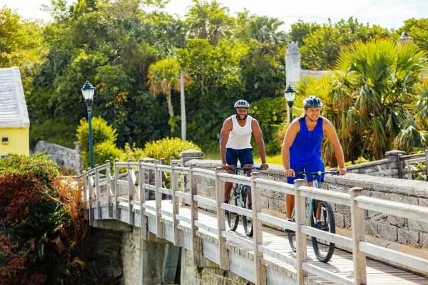 Two bikers ride their bicycles ride along a bridge in Bermuda