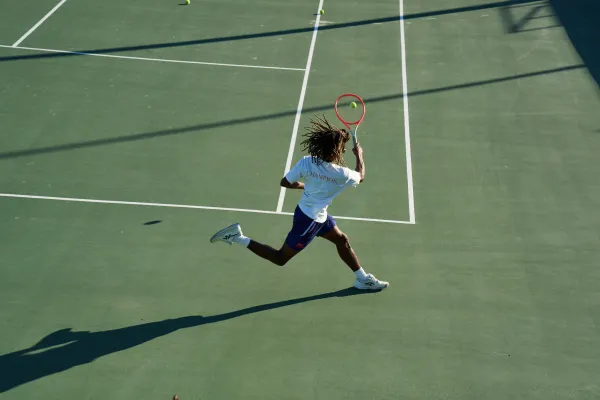 A man lunges to return a serve on a tennis court in Bermuda