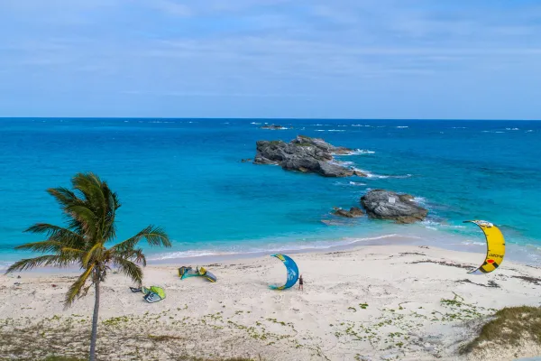 Two people kite surfing on a beach in Bermuda