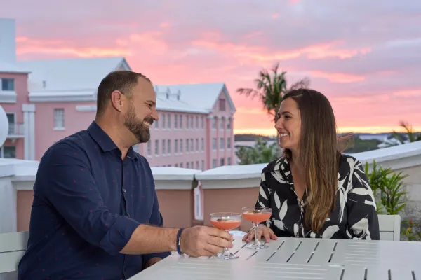A couple enjoys a meal on an outdoor balcony in Bermuda