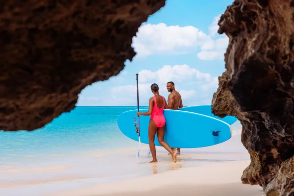 A couple with paddle boards heading to the water in Bermuda