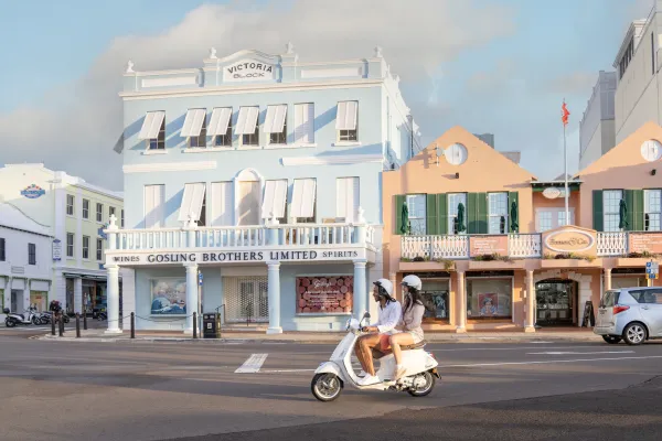 A couple on a moped rides past historic buildings on Front Street in Hamilton, Bermuda