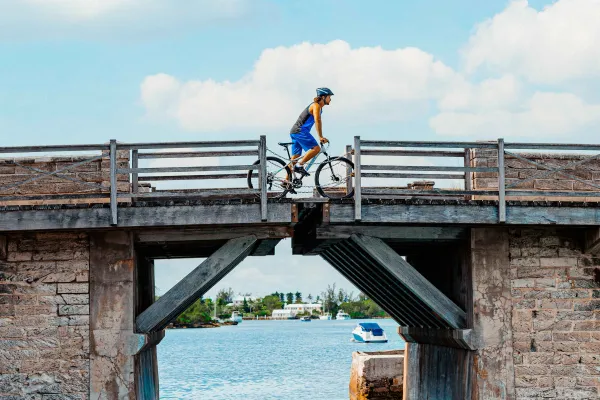 A person bikes across an old bridge in Bermuda