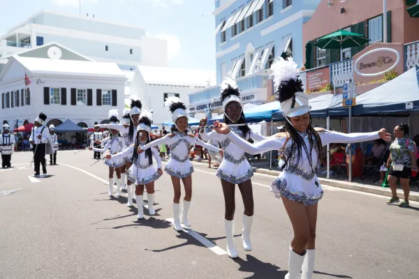 The Bermuda day parade featuring a line of baton twirling majorettes in white costumes