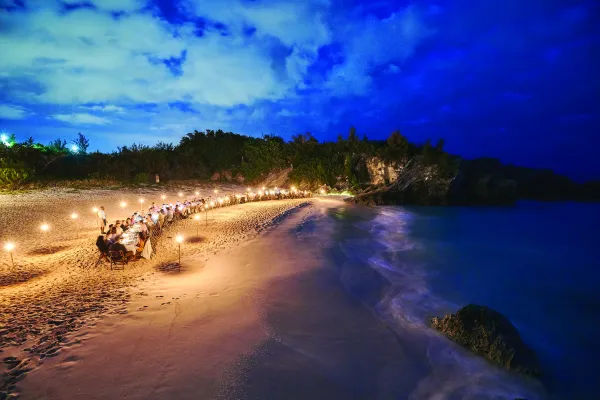 wedding dinner on beach in the evening lit by torches 