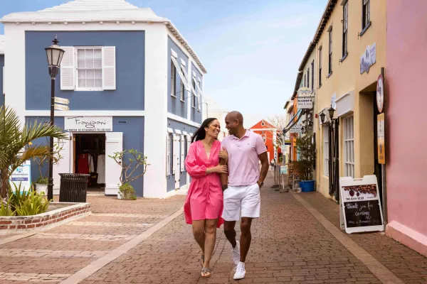 A couple walking arm in arm down a street in St. George's