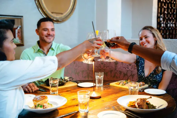 Friends are cheering at the dinner table.