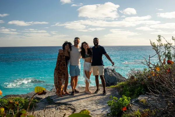 A group of friends are posing by the waterside.