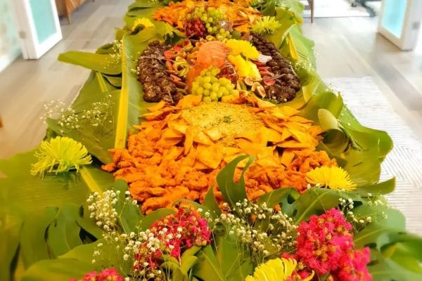 A colourful spread of fruits on a table covered in palm leaves.