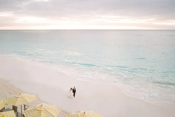bride and groom walking on a beach