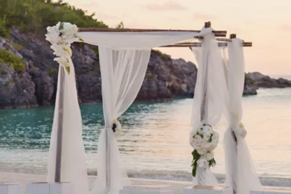 A wedding arch on a beach at sunset