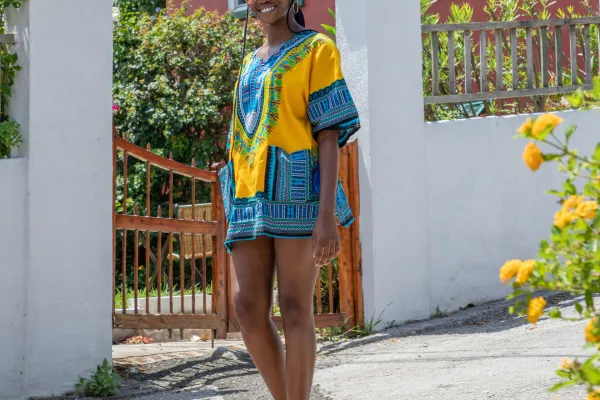 Young woman standing in front of a brightly coloured house
