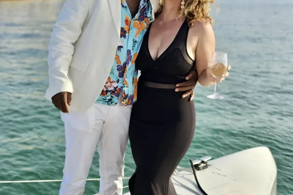 A couple is smiling on boat.