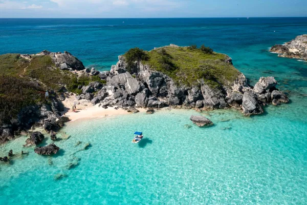 A family is on an island with a boat parked nearby.