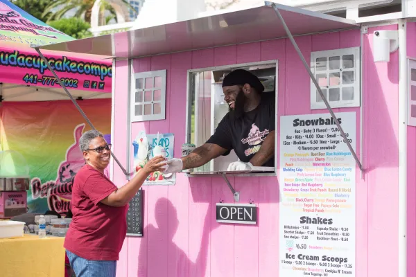A man is handing an snowball to a woman.