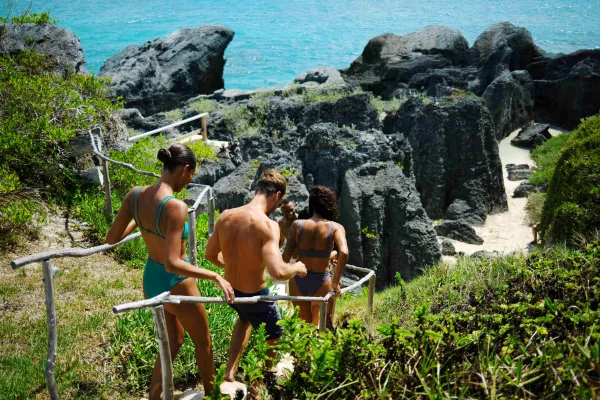 A group of friends are walking down to a secluded beach.