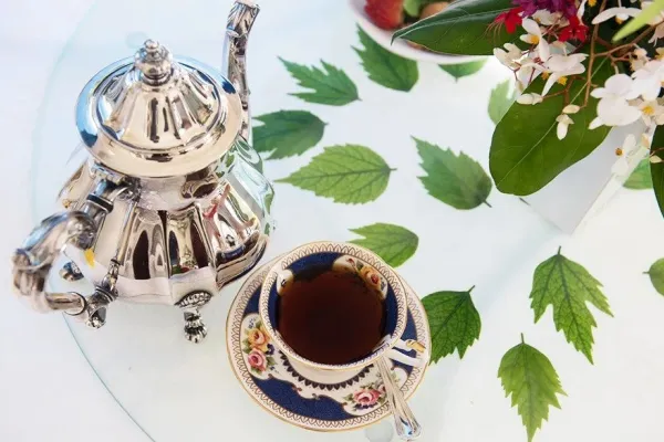 cup of tea with teapot on table