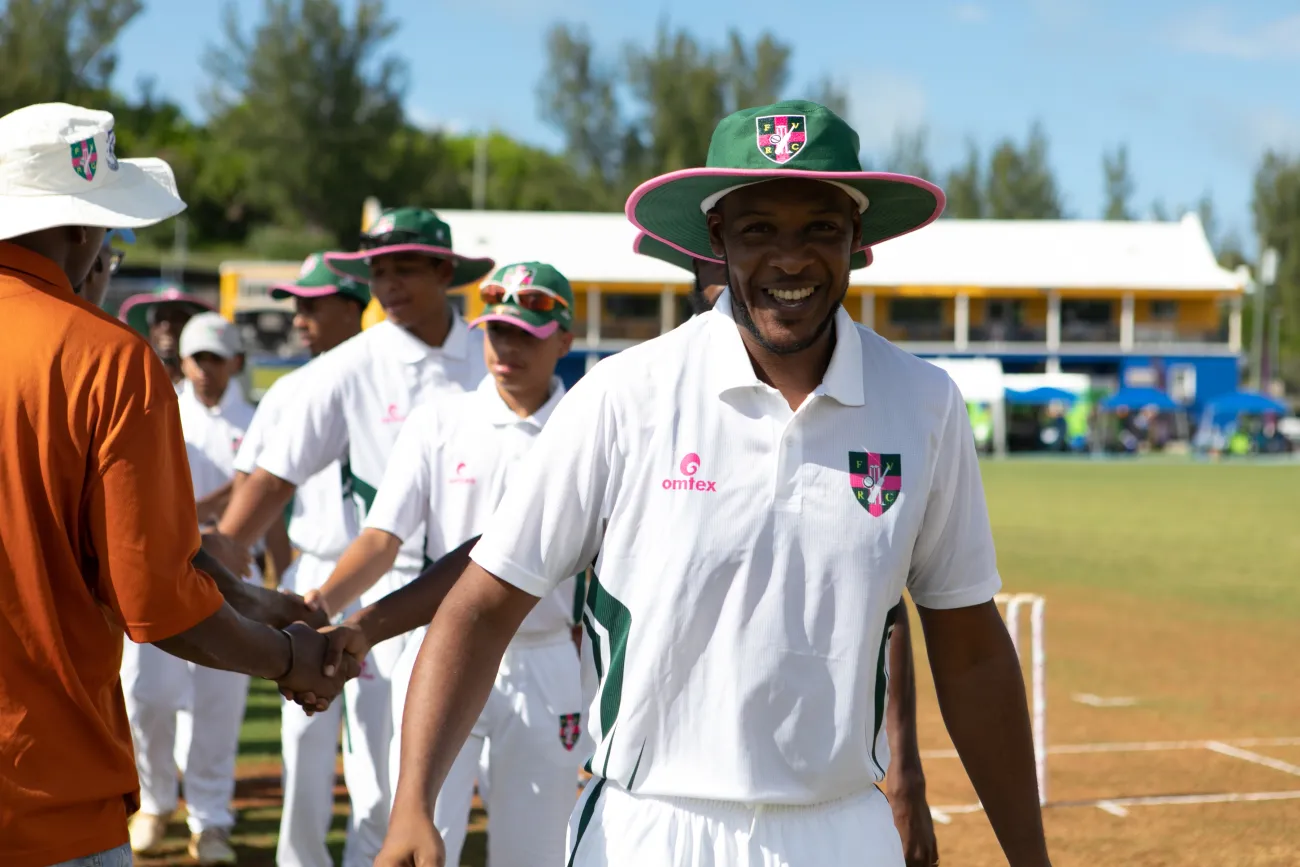 A cricket player is smiling at the camera.