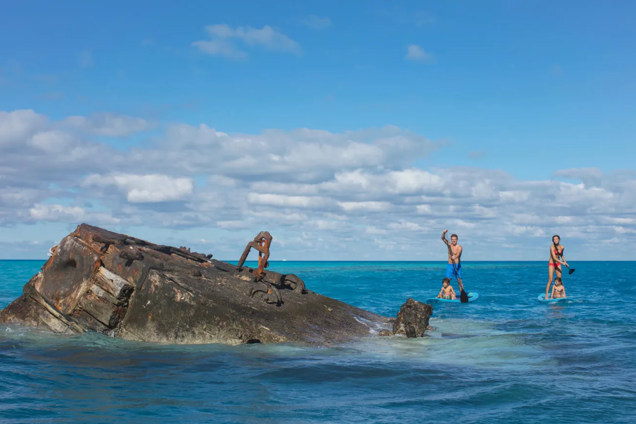 Family paddleboarding near the HMS Vixen
