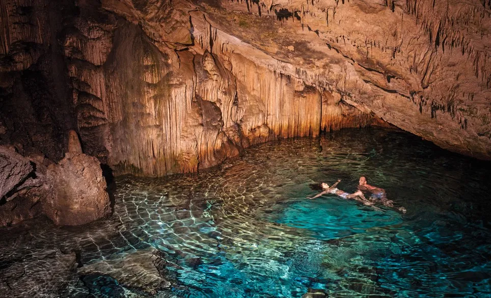 couple swimming in underwater cave