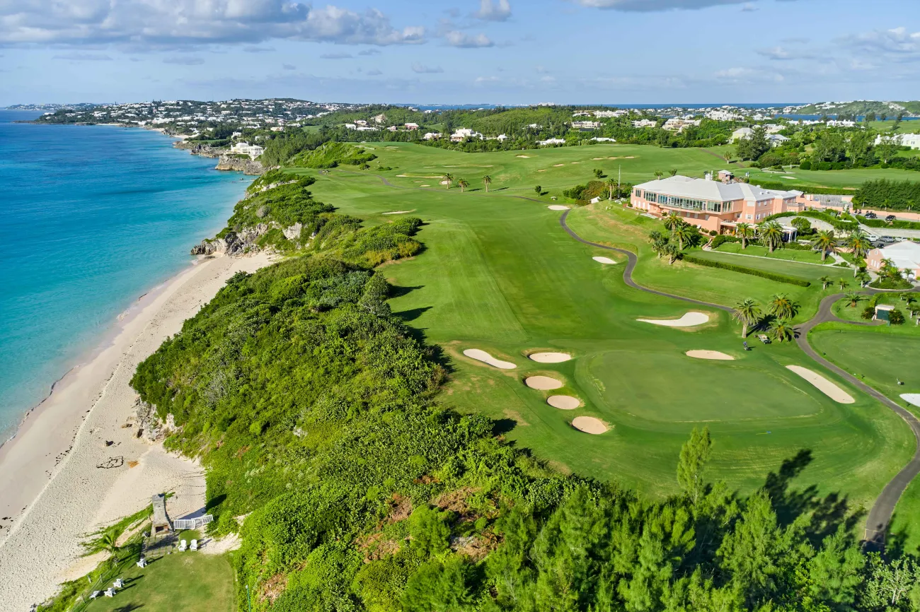 Mid aerial view of Mid Ocean with a beach beside it.