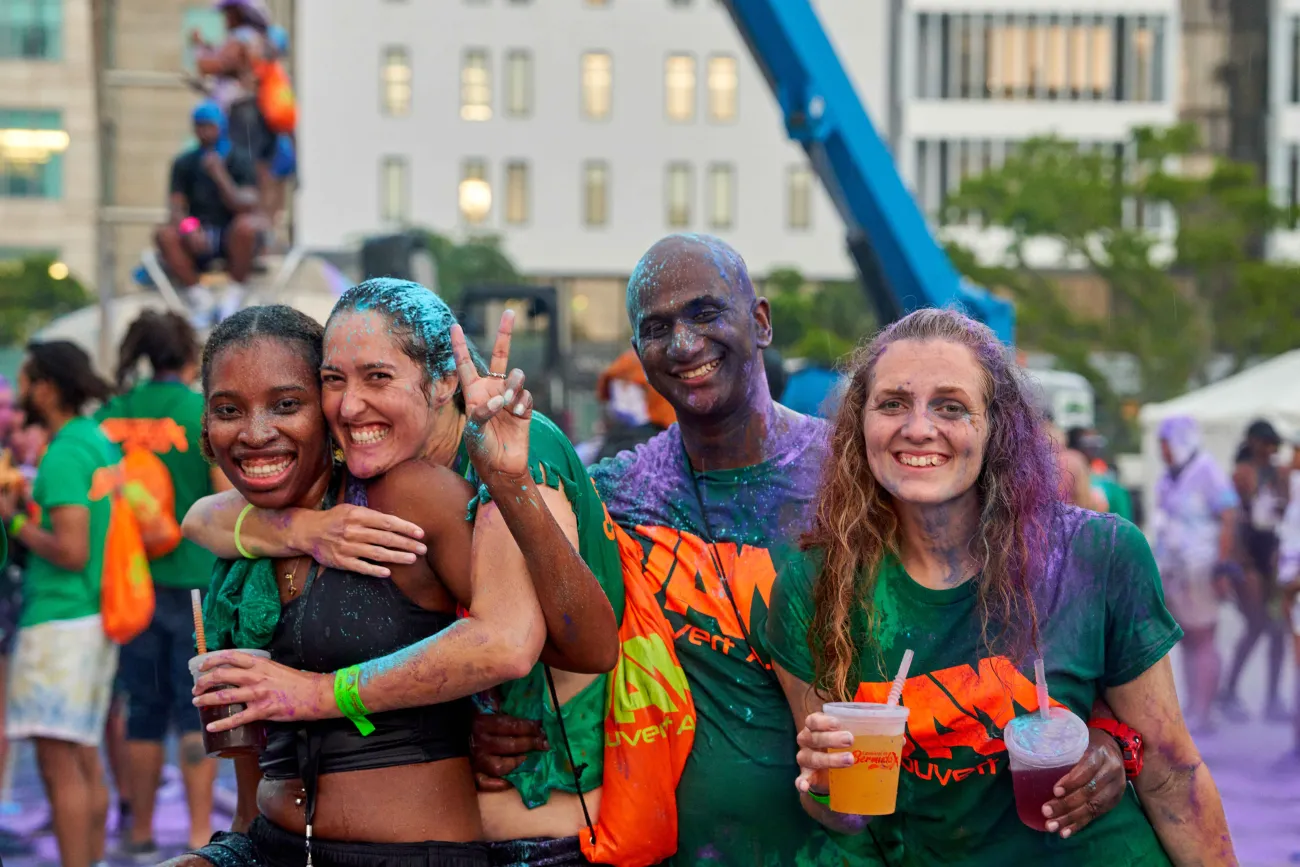 A group of friends are covered with paint at jouvert. 