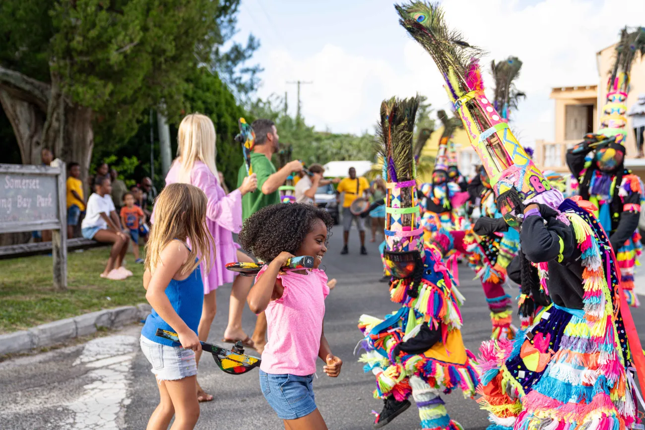 A little girl is dancing with gombey troupes.
