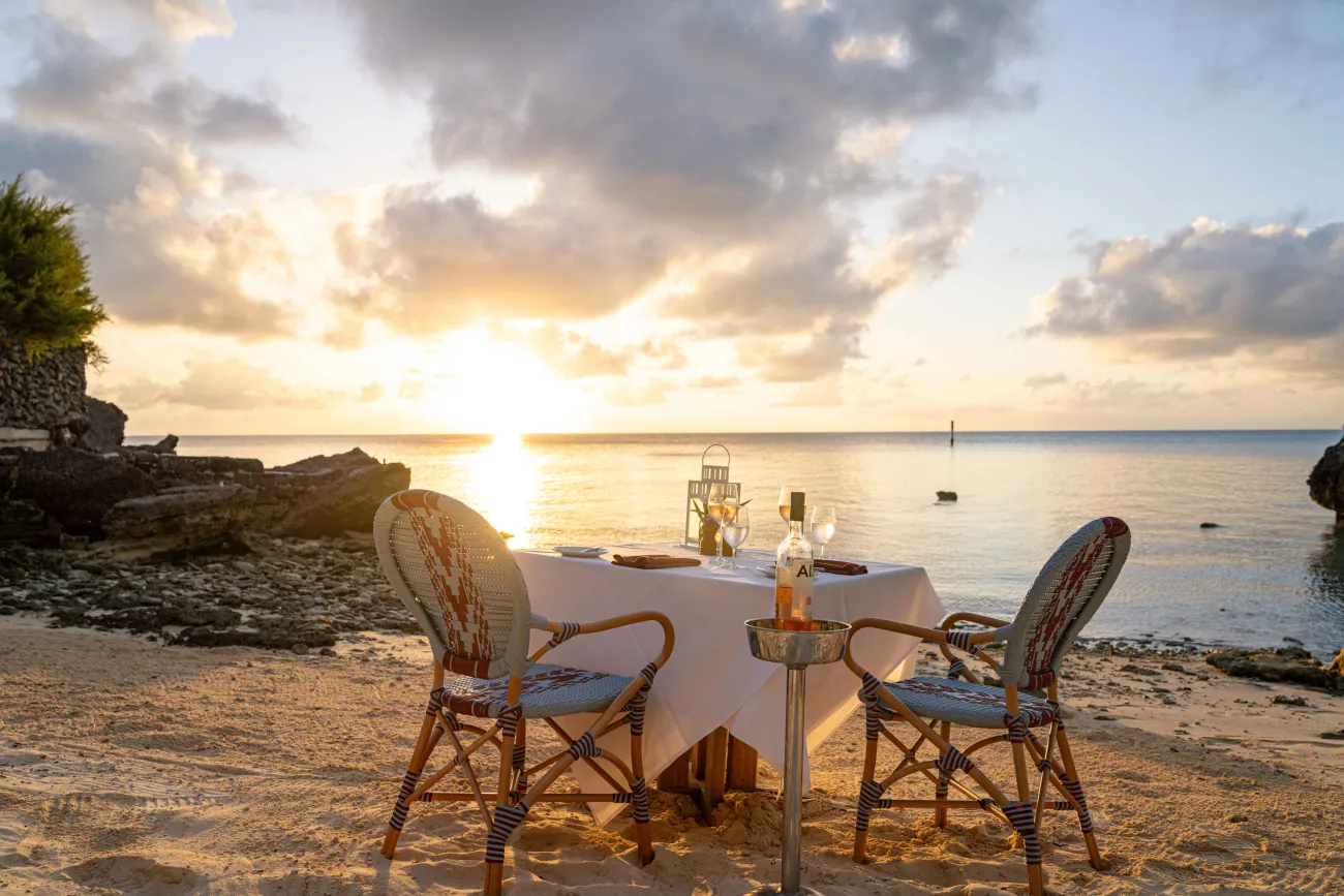 An empty table set up with the sunset setting in the background.