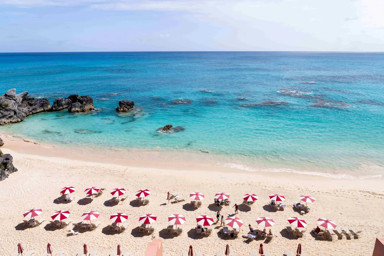 An aerial view of a hotel with beach chairs and umbrellas.