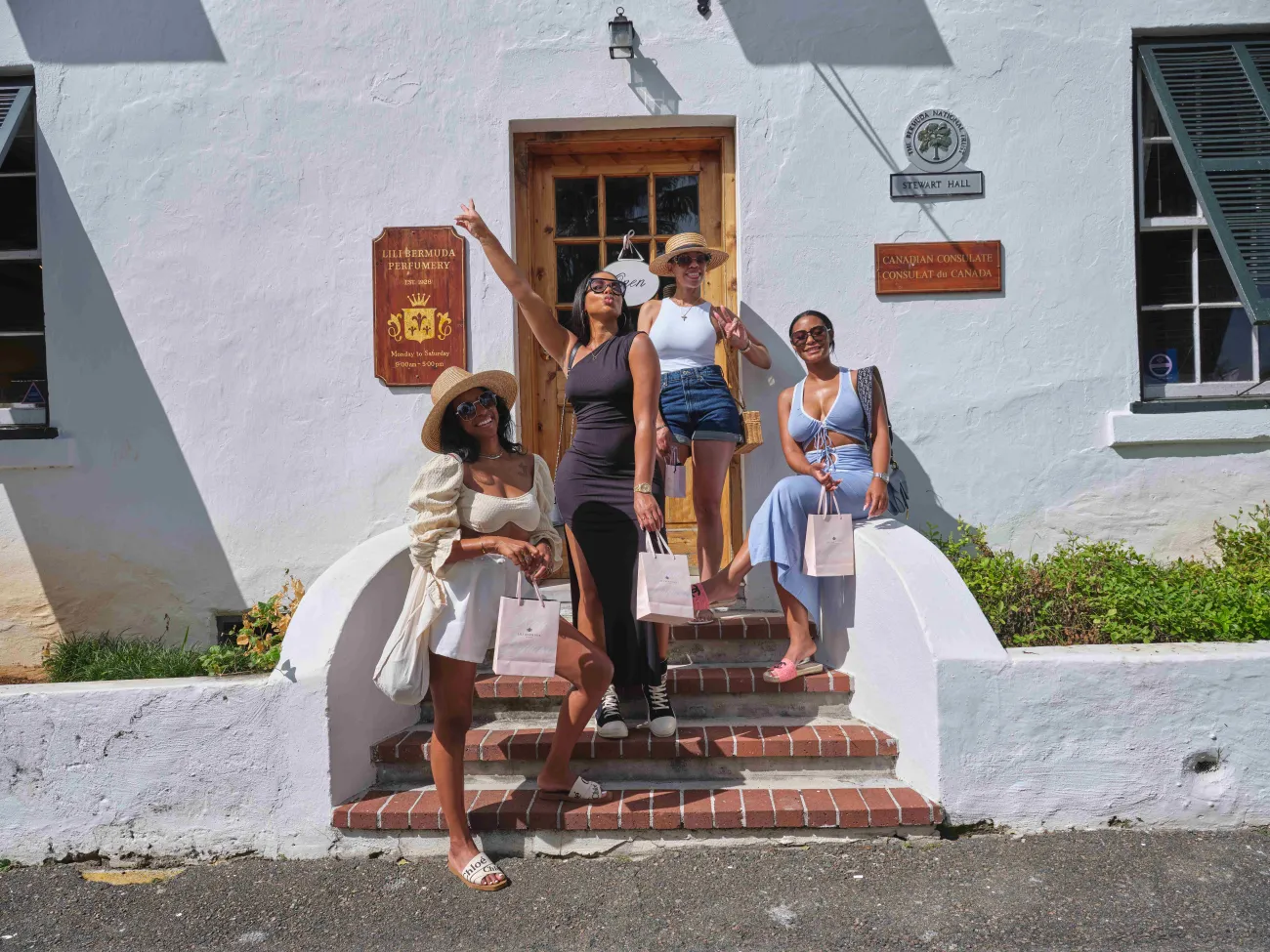 A group of friends are posing outside of Lili Bermuda