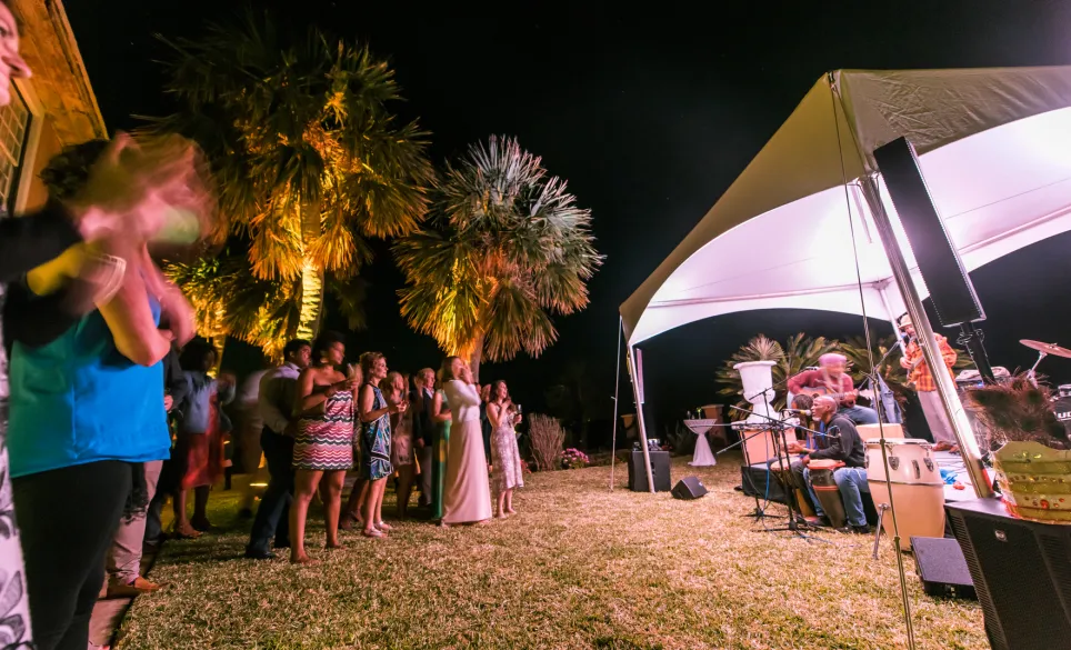 A party at night with a live band performing under a tent