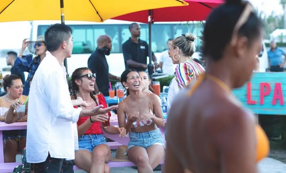 A group of people sitting at a picnic table on a patio