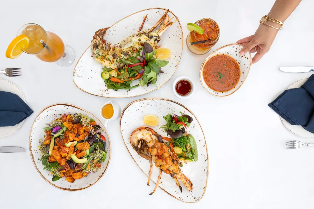 A spread of lobster on a white table with cocktails.