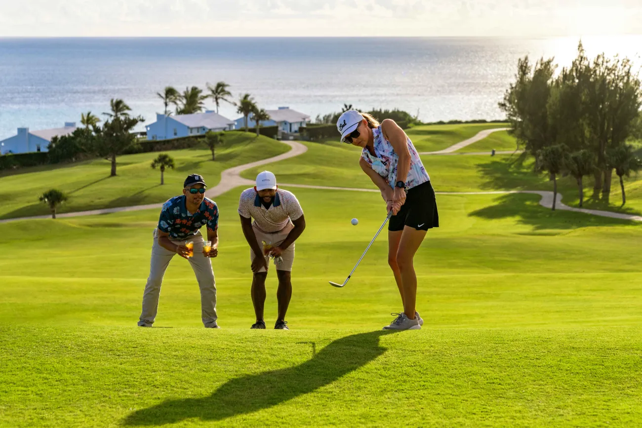 A group of people are playing golf on the course.