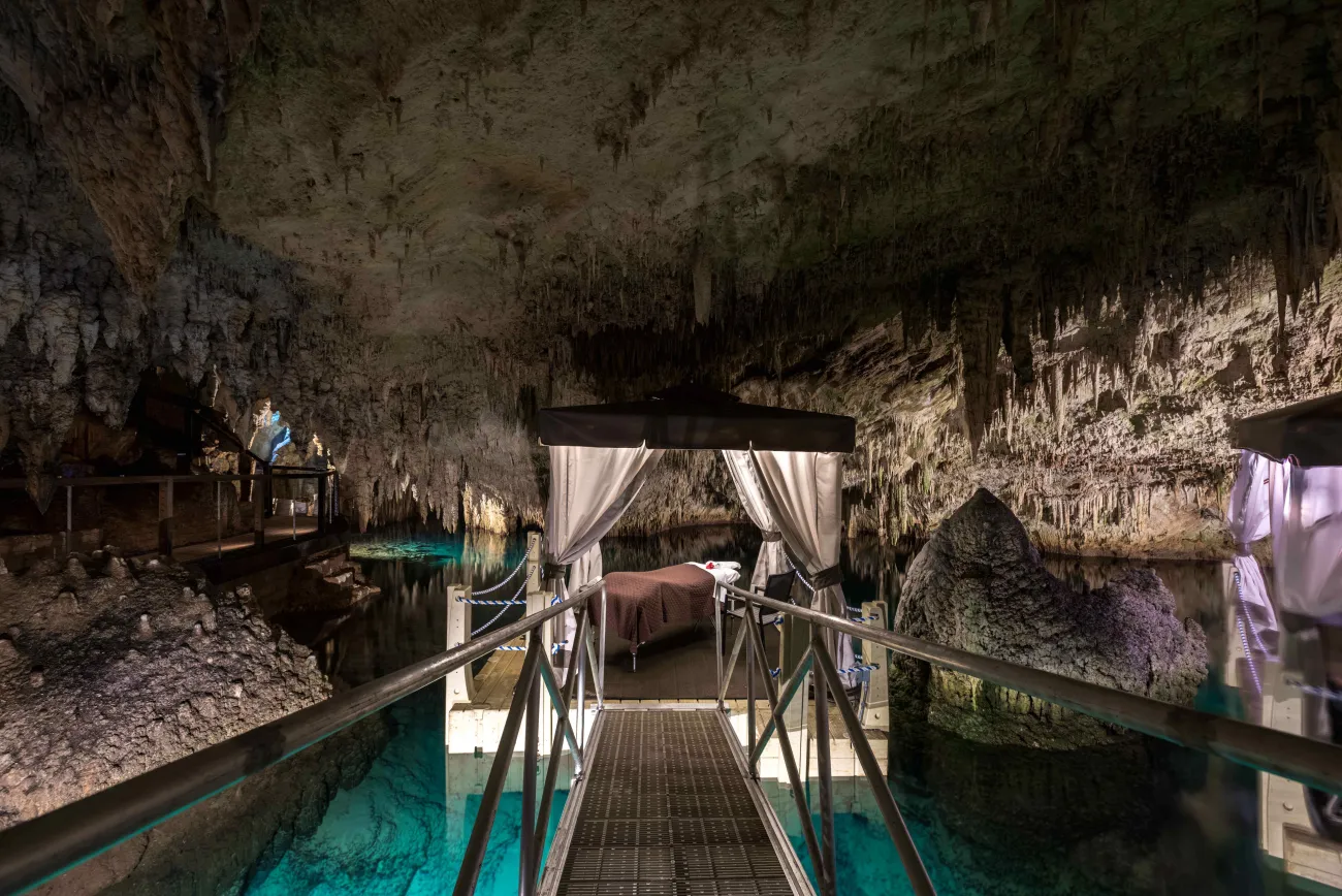 A floating dock with a massage table on it in a stunning cave in Bermuda.