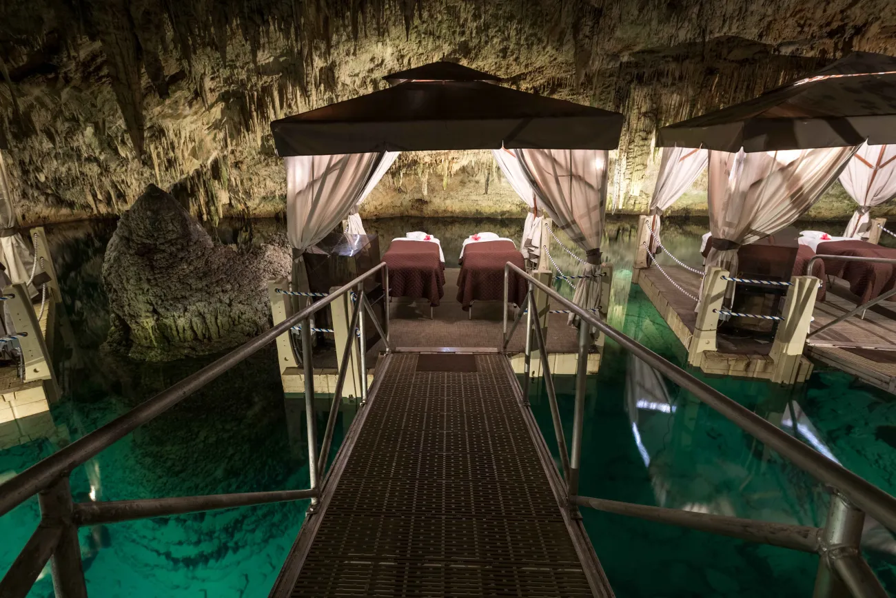A couples massage beds on a floating platoon in a cave.