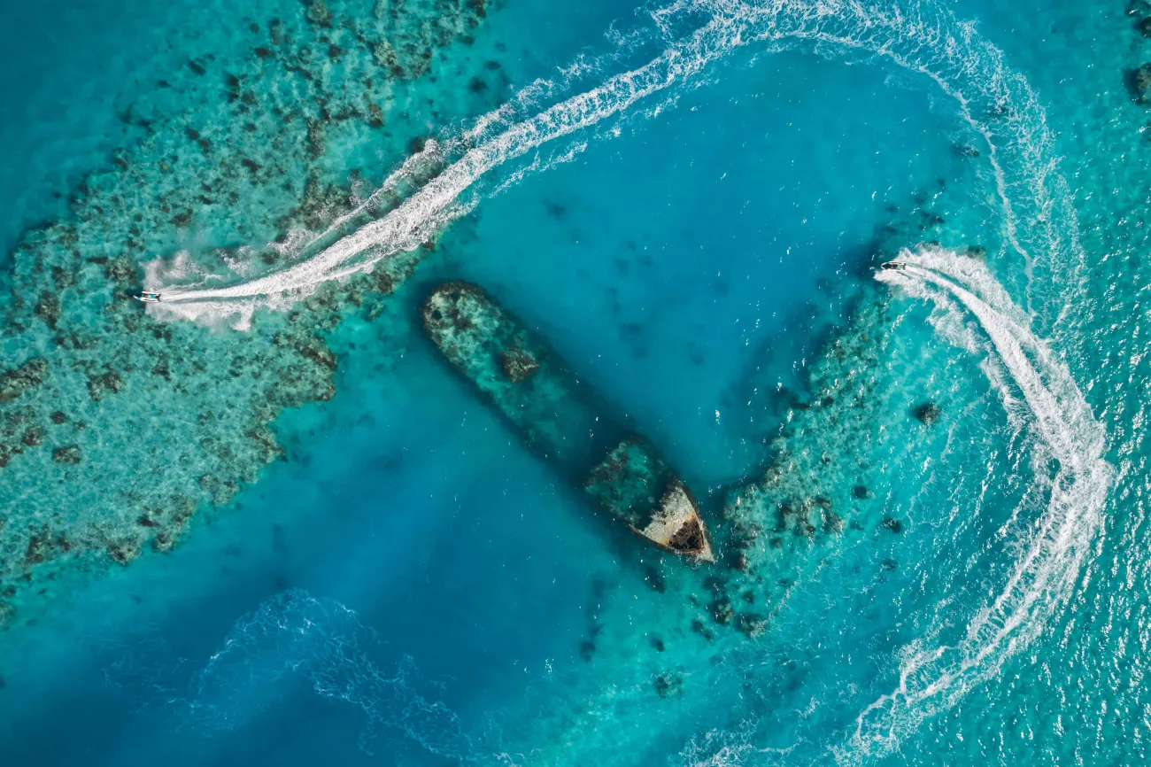 Aerial of jetskis circling around a shipwreck