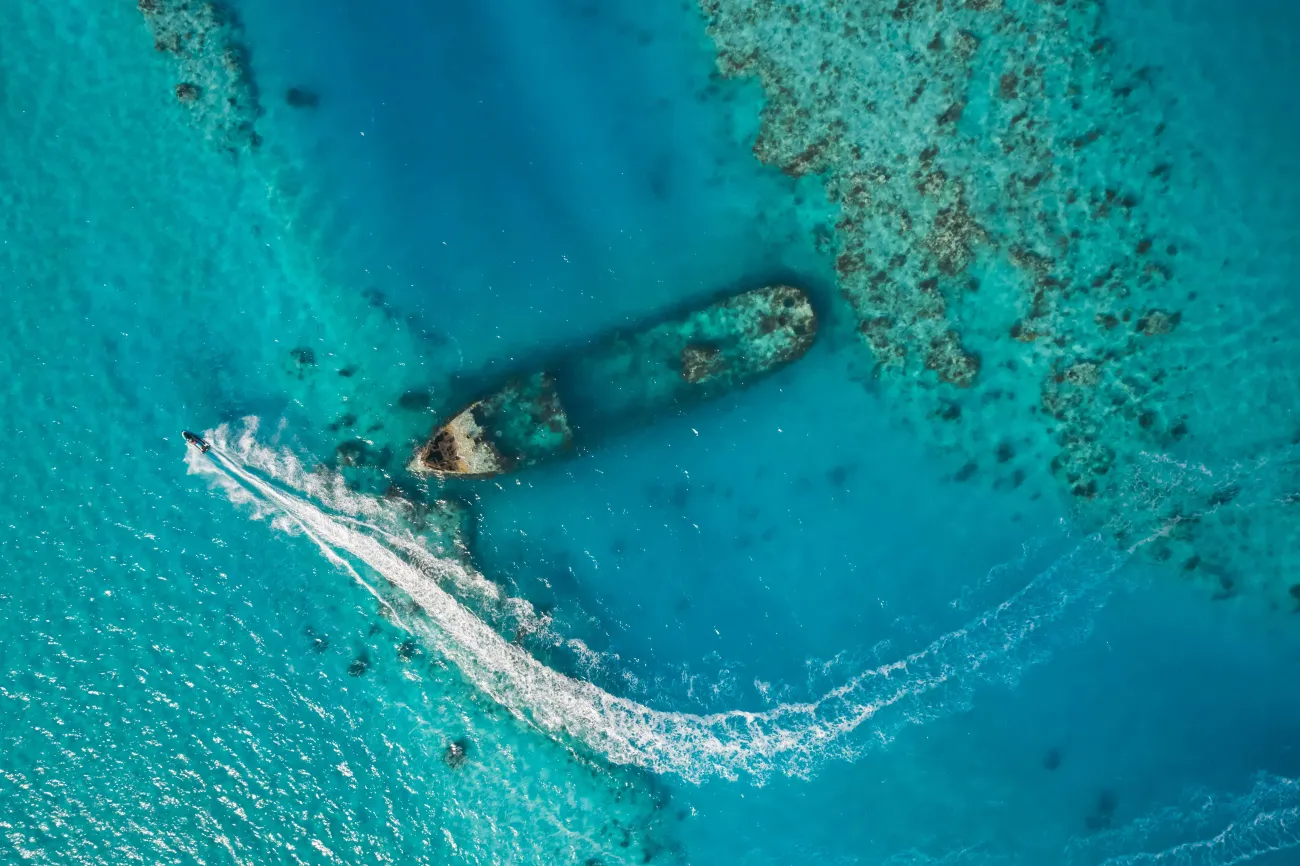 An aerial view of HM vixen with a jet ski driving by.