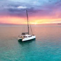 A boat in blue water at sunset